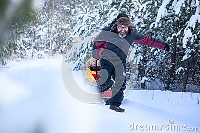 Father in winter clothes pulling sledges with his son in winter snowy forest. Happy family walk in snowy forest Stock Photo