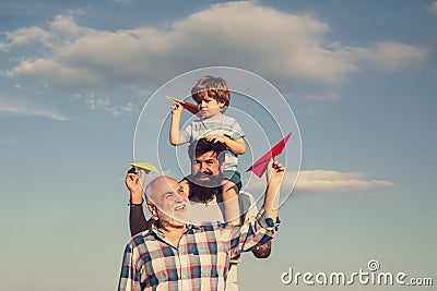 Fathers day - grandfather, father and son are hugging and having fun together. Airplane ready to fly. Portrait of happy Stock Photo