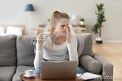 Fatigued woman feels eye strain rubbing eyes taking off glasses Stock Photo