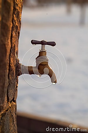 Faucet dripping water in snowy weather Stock Photo