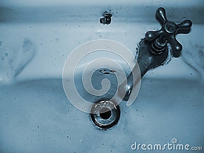 Faucet of an old and deteriorated washbasin Stock Photo