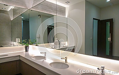 Faucets with washbasin and big mirror Stock Photo