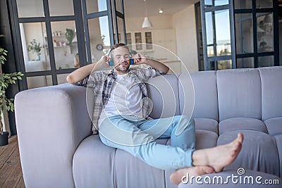 Handsome man wearing checked shirt listening to favorite song Stock Photo