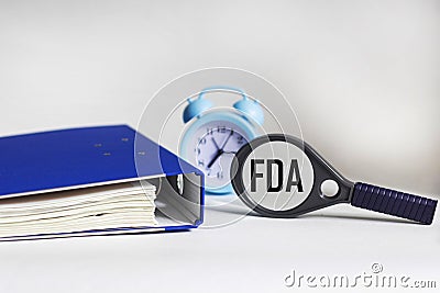 FDA concept. Concept of the Food and Drug Administration. Magnifier glass, folder and clock Stock Photo