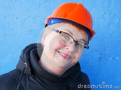 Feamle Engineer in the construction helmet on blue background, closeup Stock Photo