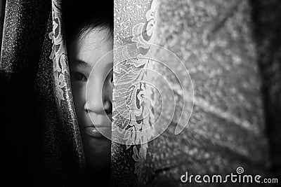 Fear girl hiding behind curtain with shadow edge Stock Photo