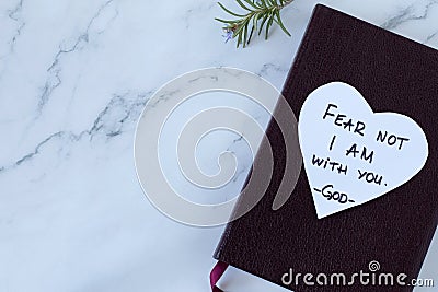 Fear not, I am with you, handwritten verse on heart shaped note on top of closed holy bible book, top view, copy space Stock Photo
