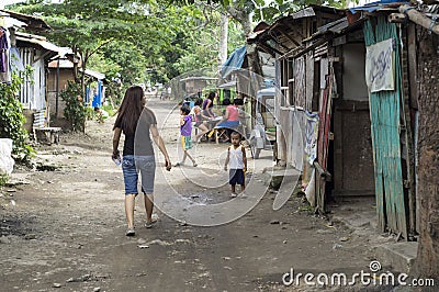 Fearless Young lady walking along on a slum rough road street unaccompanied Editorial Stock Photo