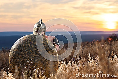 Fearless young Spartan warrior posing in the field Stock Photo
