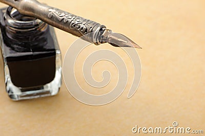 Feather quill and inkwell on an old paper Stock Photo