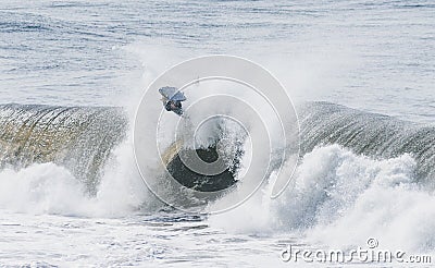 Amazing shot of a professional surfer surfing in the sea with big waves in summer Editorial Stock Photo