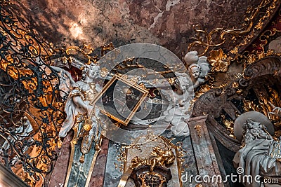 Feb 2, 2020 - Munich, Germany: Angel holding painting on ceiling of entrance hall of Asamkirche Editorial Stock Photo