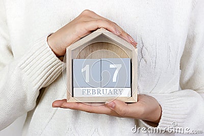 February 17 in the calendar. the girl is holding a wooden calendar. Random Acts of Kindness Day Stock Photo