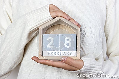 February 28 in the calendar. the girl is holding a wooden calendar. Rare Disease Day, Shrove Tuesday, International Pancake Day Stock Photo