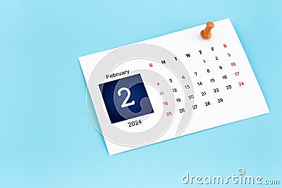 February 2024 calendar page with push pin on blue Stock Photo