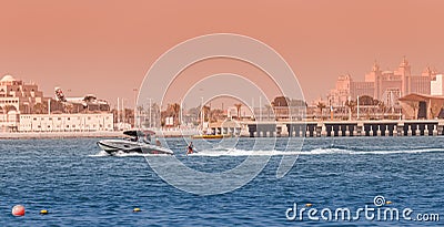 Highspeed motorboat pulls a person in tow on water skis or a board. Extreme and entertaining types Editorial Stock Photo