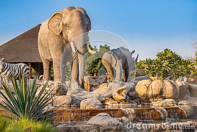 Zebra, elephant and crocodile statues on an artificial fountain and waterfall in the central safari Editorial Stock Photo