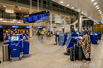 February 18, 2019. Kastrup Airport Denmark Copenhagen. Woman backs unrecognizable with large suitcases baggage independently Editorial Stock Photo