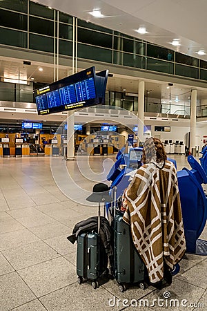 February 18, 2019. Kastrup Airport Denmark Copenhagen. Woman backs unrecognizable with large suitcases baggage independently Editorial Stock Photo