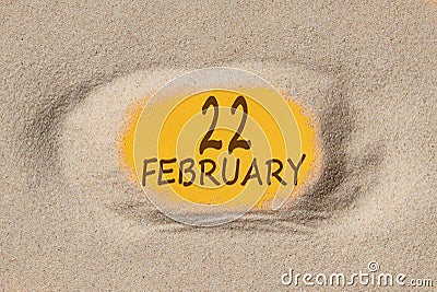 February 22. 22th day of the month, calendar date. Hole in sand. Yellow background is visible through hole Stock Photo