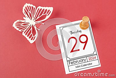 February 29th mini calendar for February 29 and wooden push pin on red background Stock Photo