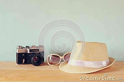 Fedora hat, sunglasses old vintage camera over wooden table. relaxation or vacation concept Stock Photo