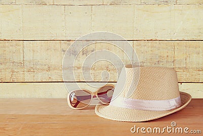 Fedora hat and sunglasses over wooden table. relaxation or vacation concept Stock Photo