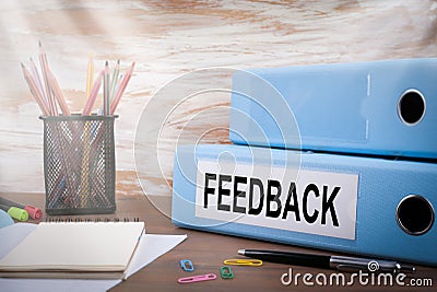 Feedback, Office Binder on Wooden Desk. On the table colored pencils, pen, notebook paper Stock Photo