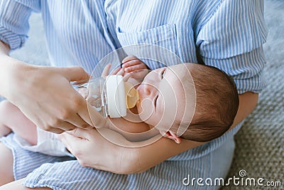 Feeding the newborn with a mixture in a bottle Stock Photo