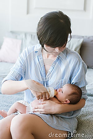 Feeding the newborn with a mixture in a bottle Stock Photo