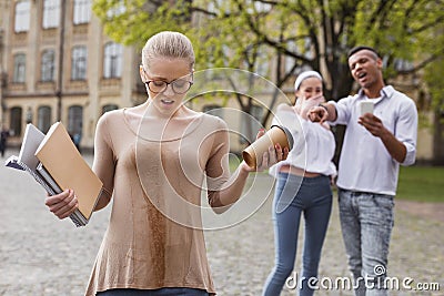 Confused student feeling awful after spilling tea on her clothes Stock Photo