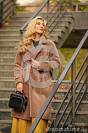 Feeling cold. sexy blong woman. autumn season. european winter. girl warm coat stairs background. faux fur coat fashion Stock Photo