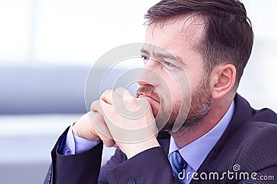 Feeling exhausted. Frustrated young beard man massaging his nose and keeping eyes closed while sitting at his working Stock Photo