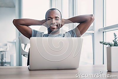 Young businessman working on his laptop in spacious bright office. Stock Photo