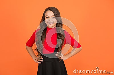 Feeling lucky. Perfect girl. Positive emotions. Teen girl smiling orange background. Teen child with long curly hair Stock Photo