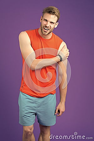 Feeling that pain again. Athlete injured shoulder joint. Man suffers old trauma chronic pain violet background Stock Photo