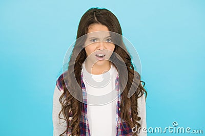Feeling surprised. amazed small girl turquoise background. schoolgirl has long curly hair. child wear trendy casual Stock Photo