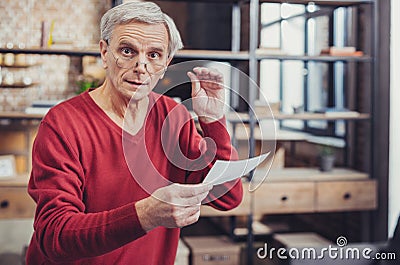 Aged man feeling surprised after receiving the bills Stock Photo