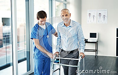 Feels great to be hitting the road to recovery. Portrait of a senior patient with a walker getting assistance from a Stock Photo