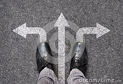 Feet and arrows on road background. Selfie feet above. Businessman standing on pathway with three direction arrows choice or move Stock Photo