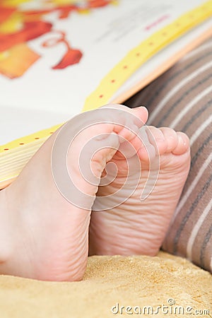 The feet of the child and the book Stock Photo