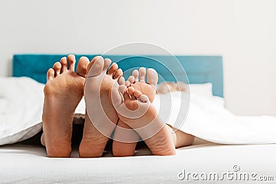 Feet close up of young loving couple enjoying on the bed Stock Photo