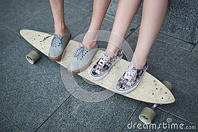 Feet couple of teenagers on the longboard closeup Stock Photo