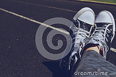 Feet crossed in shoes on track Stock Photo