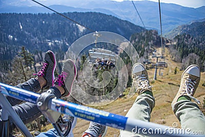 Feet of a family on a funicular on the background of the Caucasus mountains. Krasnaya Polyana - Alpine ski resort. Rosa Editorial Stock Photo