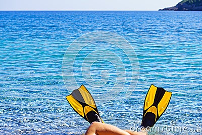Feet in flippers fins on sea shore Stock Photo