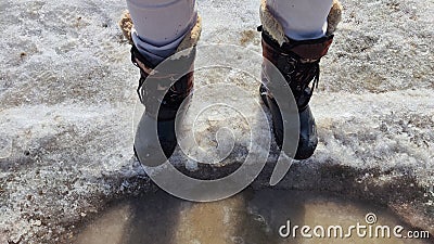 Feet of Hunter or fisherman in big warm boots on a winter day on snow. Top view. Fisherman on the ice of a river, lake Stock Photo