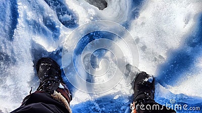 Feet of Hunter or fisherman in big warm boots on a winter day on snow. Top view. A fisherman on the ice of a river, lake Stock Photo