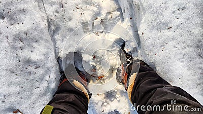 Feet of Hunter or fisherman in big warm boots on a winter day on snow. Top view. Fisherman on the ice of a river, lake Stock Photo