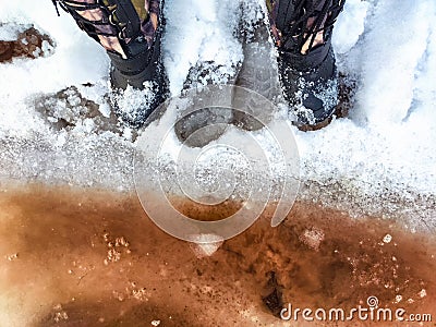 Feet of Hunter or fisherman in big warm boots on a winter day on snow. Top view. Fisherman on the ice of a river, lake Stock Photo